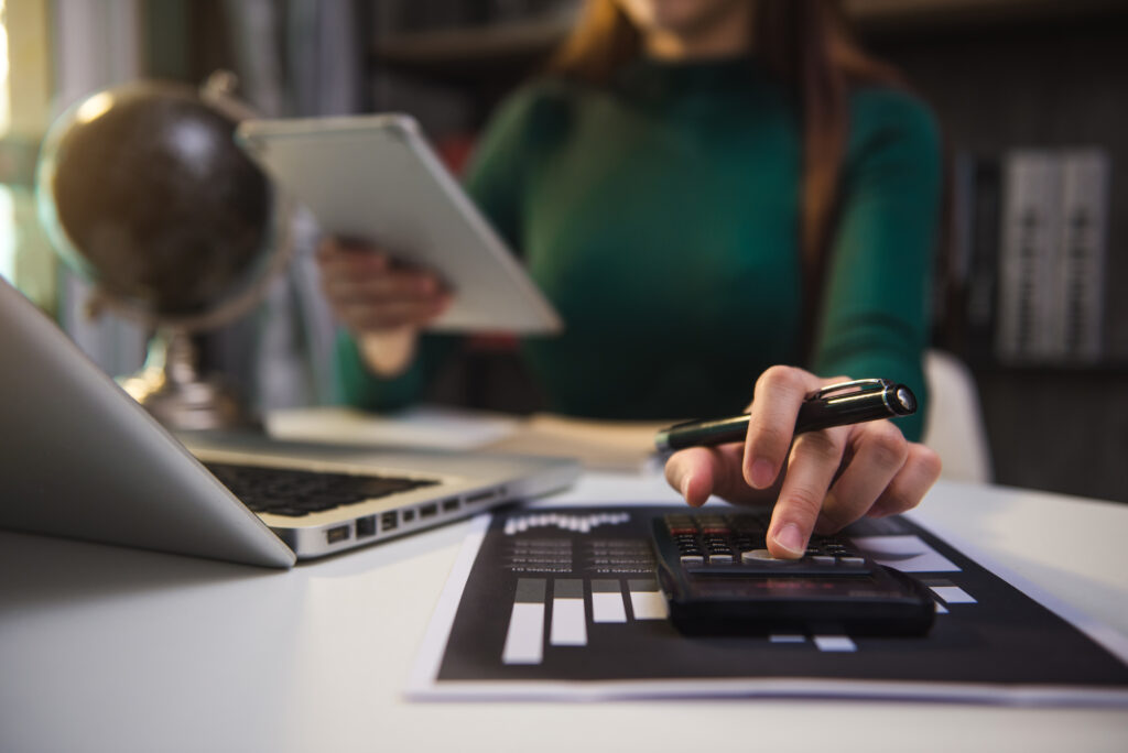 Hand business doing finances and calculate on desk about cost us